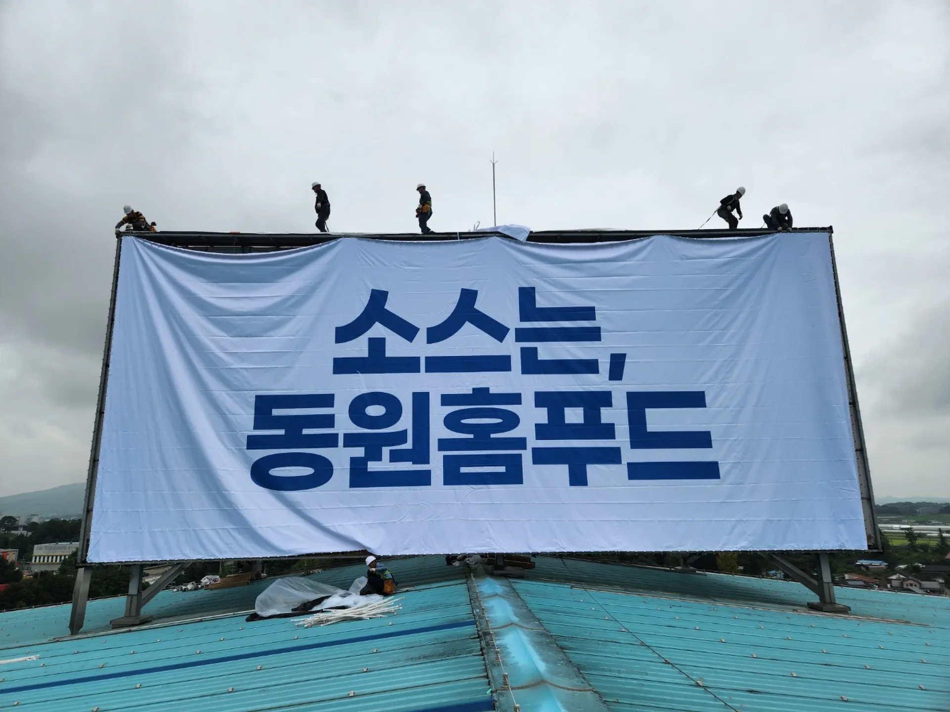 옥상광고탑 배접 화면을 설치 중인 로프 작업자들